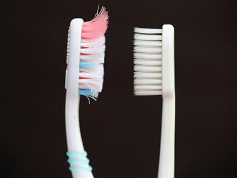 worn and new toothbrushes